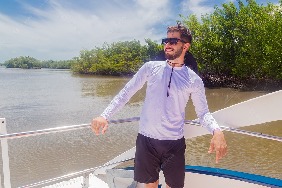 Homem jovem curtindo férias andando de lancha