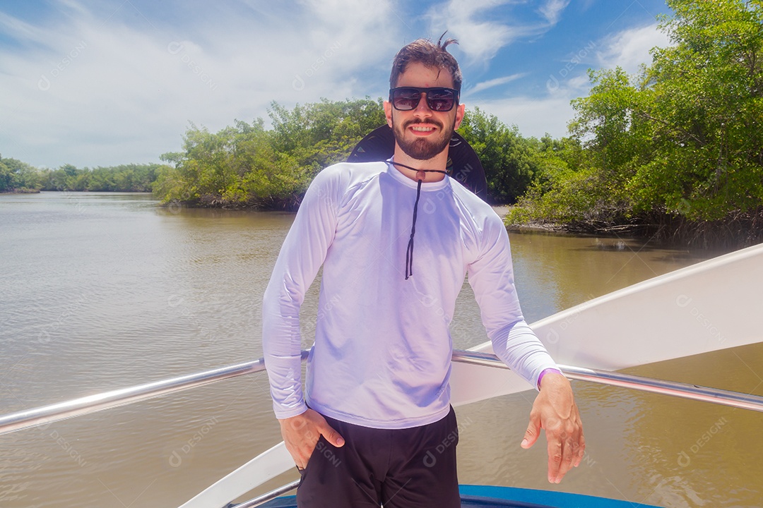 Homem jovem curtindo férias andando de lancha