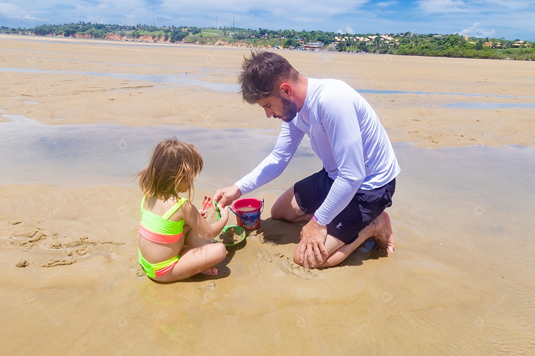 Pai brincando com sua filha sobre praia feliz férias família