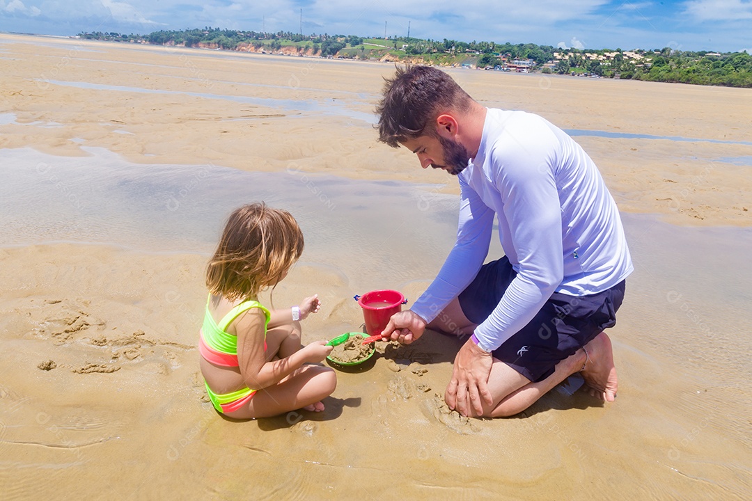 Pai brincando com sua filha sobre praia feliz férias família