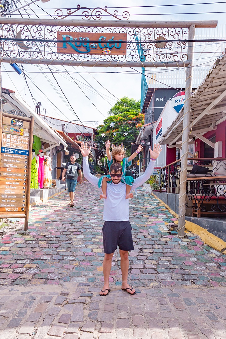 Filha no pescoço de seu pai sobre cidade turística