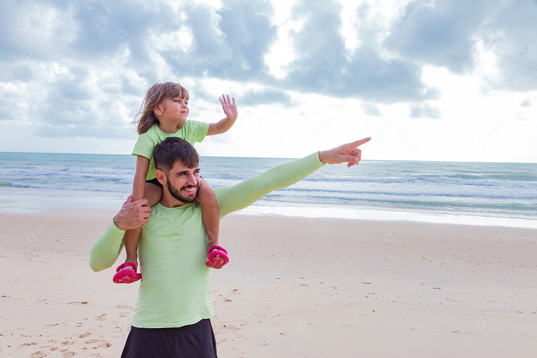 Father playing with his daughter on the beach, happy family vacation
