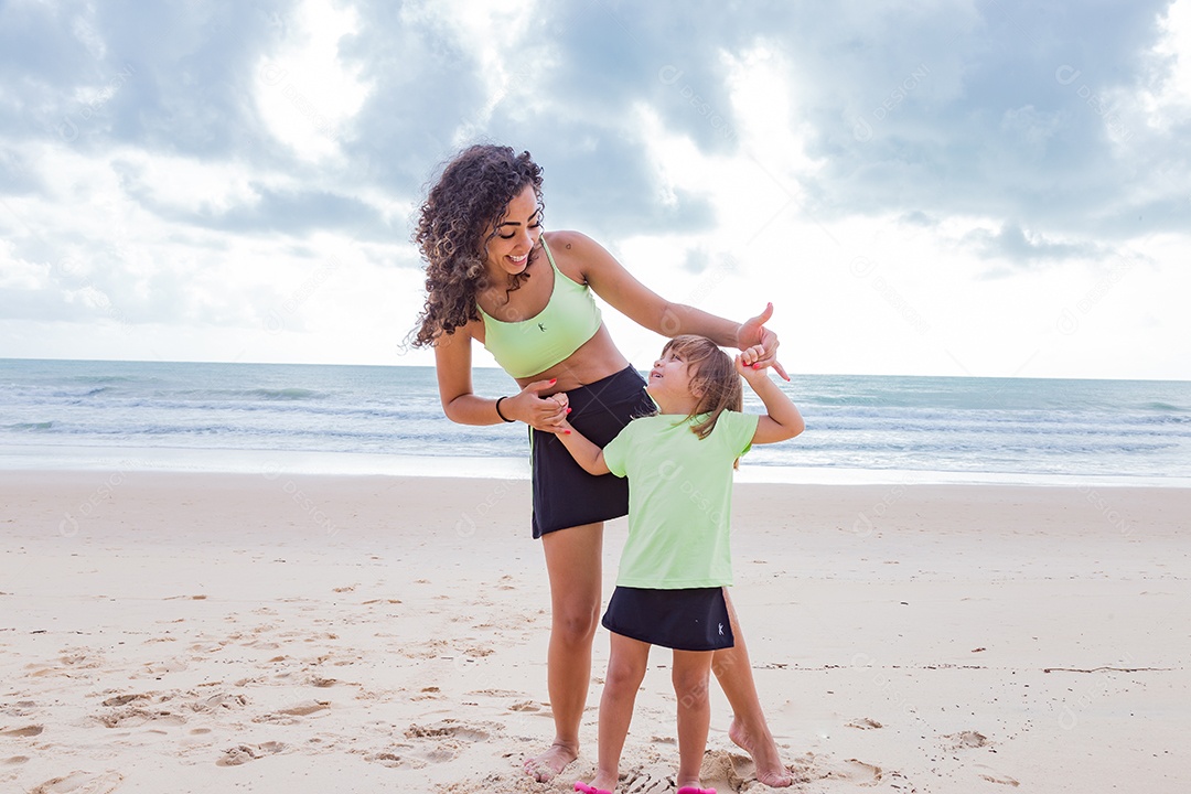 Mãe brincando com sua filha sobre praia feliz férias família