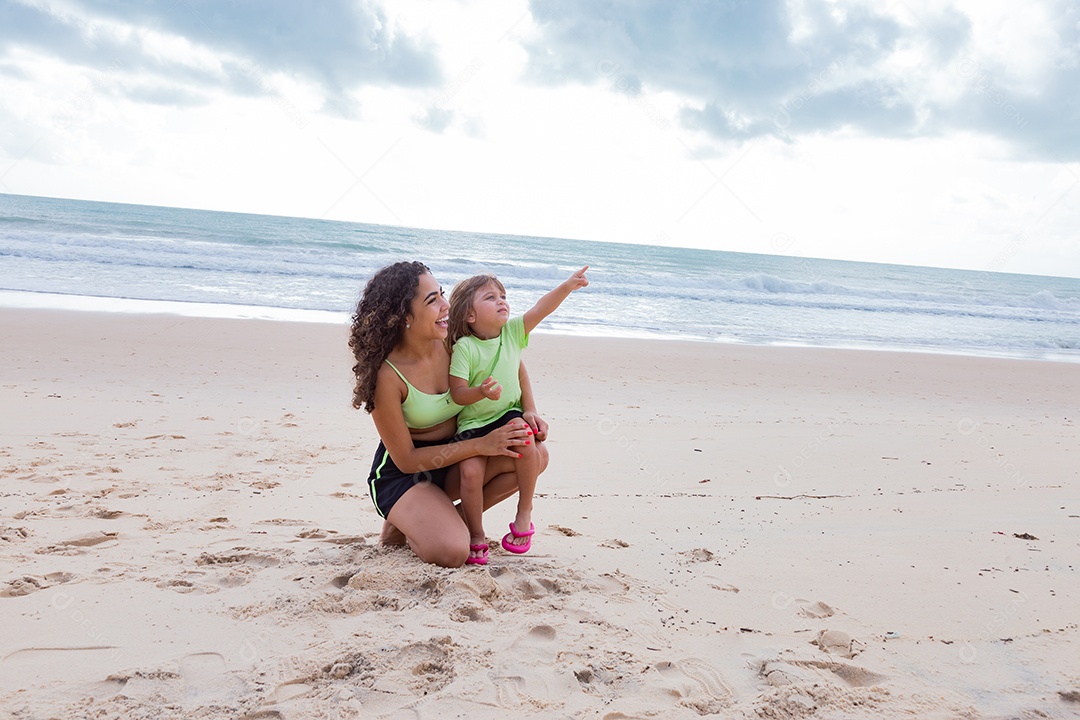 Mãe brincando com sua filha sobre praia feliz férias família