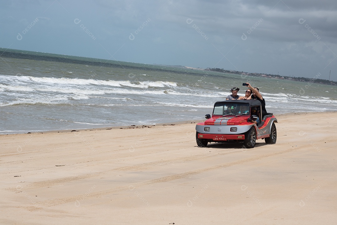 Pessoas jovens andando de carro sobre praia