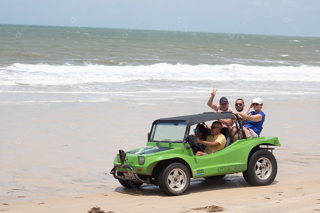 Pessoas jovens andando de carro sobre praia