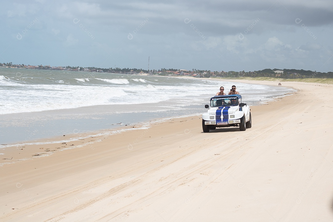 Pessoas jovens andando carro sobre praia verão férias