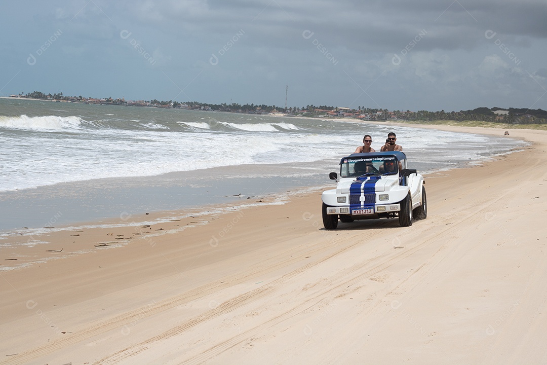 Pessoas jovens andando carro sobre praia verão férias