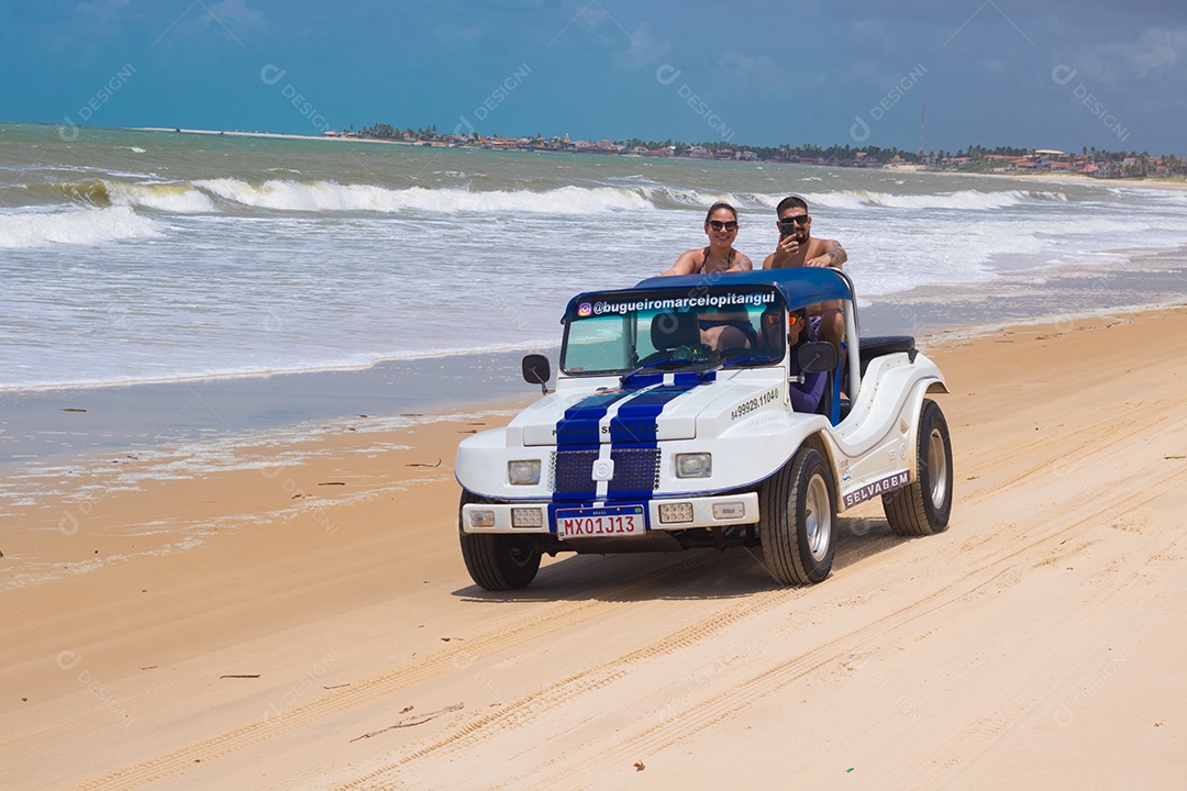 Pessoas jovens andando carro sobre praia verão férias