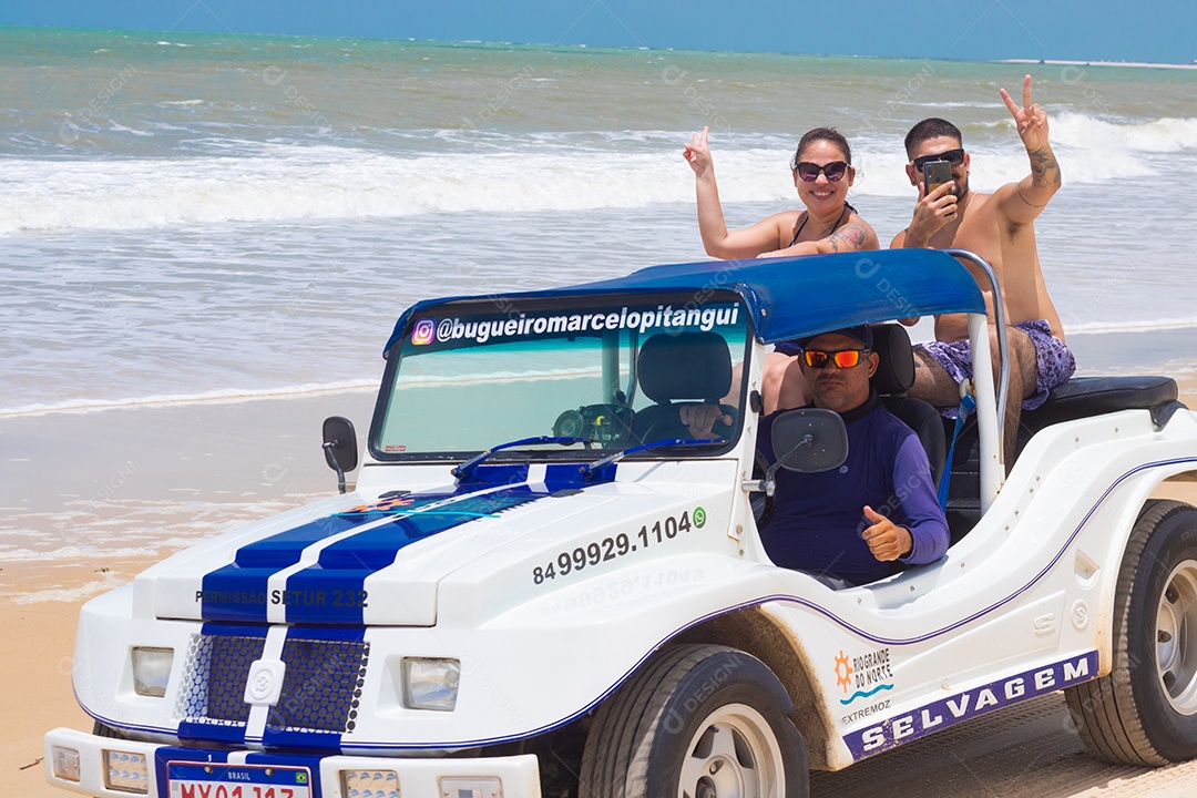 Pessoas jovens andando carro sobre praia verão férias