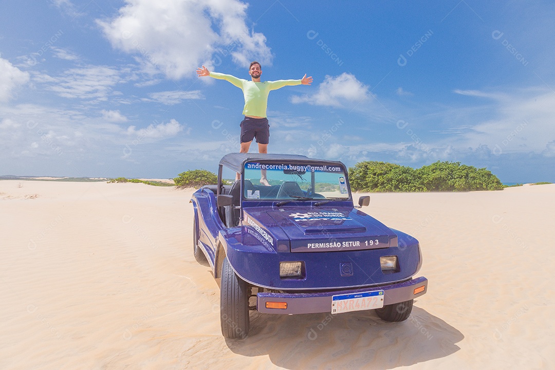 Homem jovem andando de carro sobre dunas areia