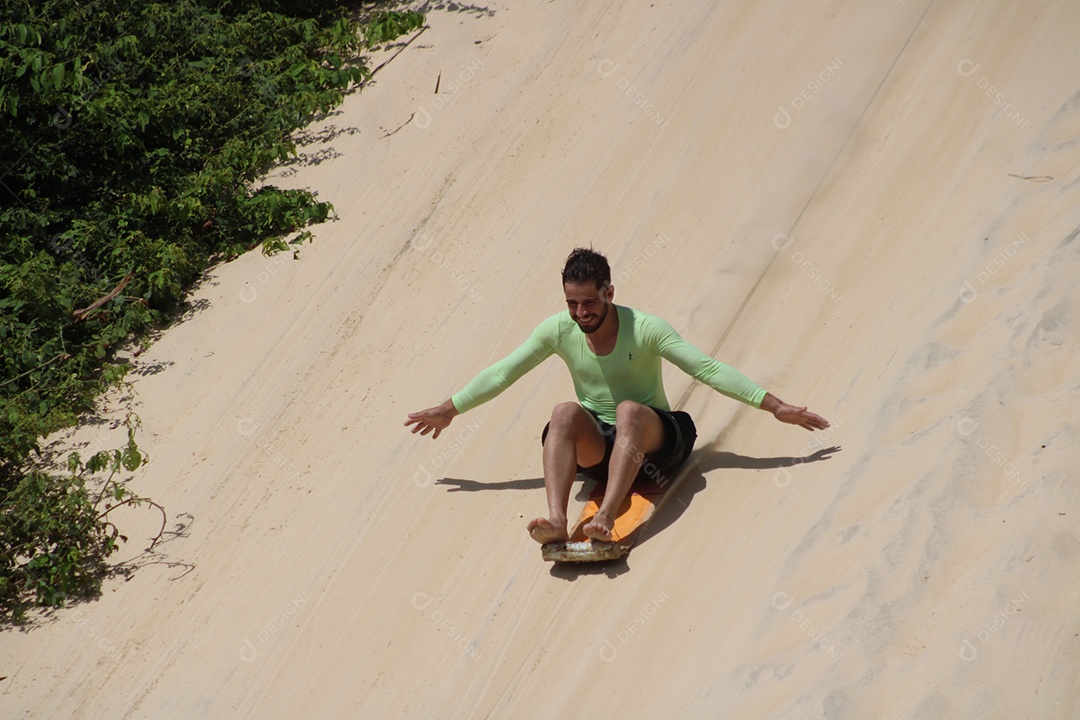 Homem jovem descendo sobre areia dunas