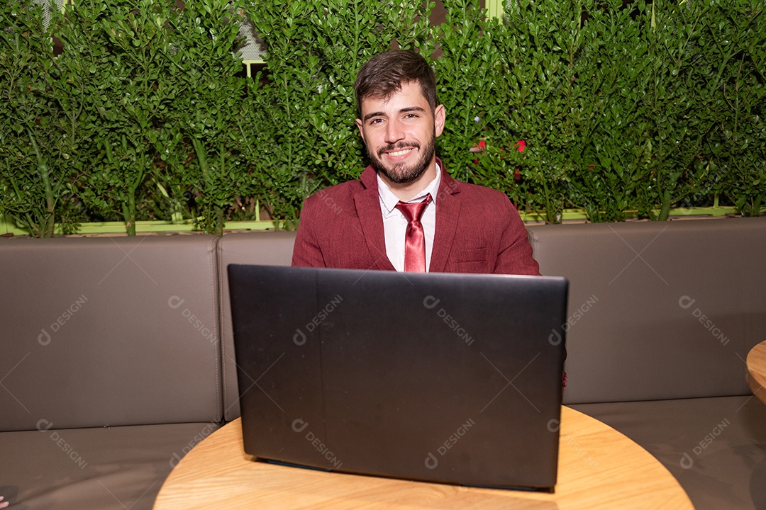 Homem jovem empresário usando terno mexendo em seu notebook