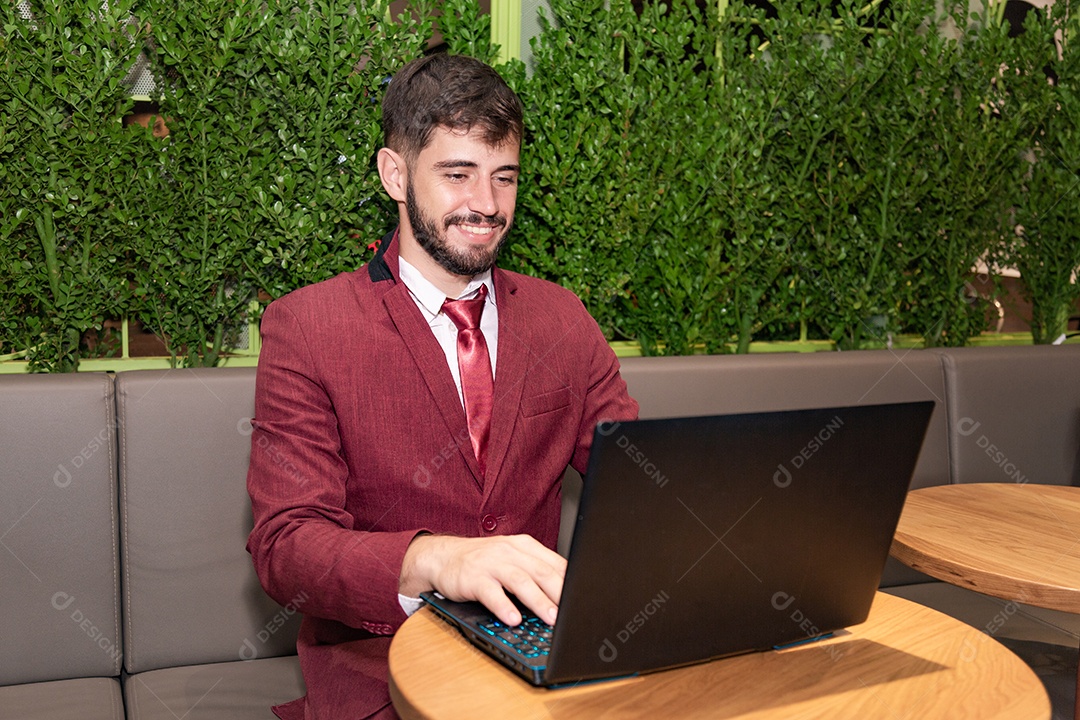 Young businessman man wearing a suit fiddling with his notebook