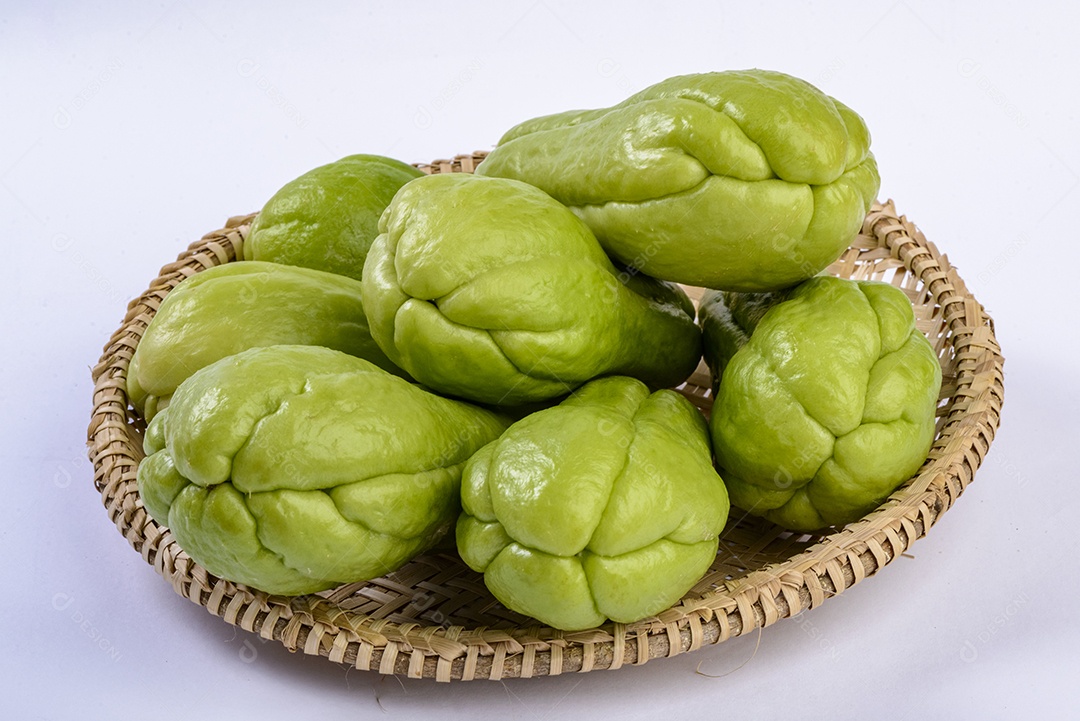 Chuchu em uma cesta de palha em fundo branco.