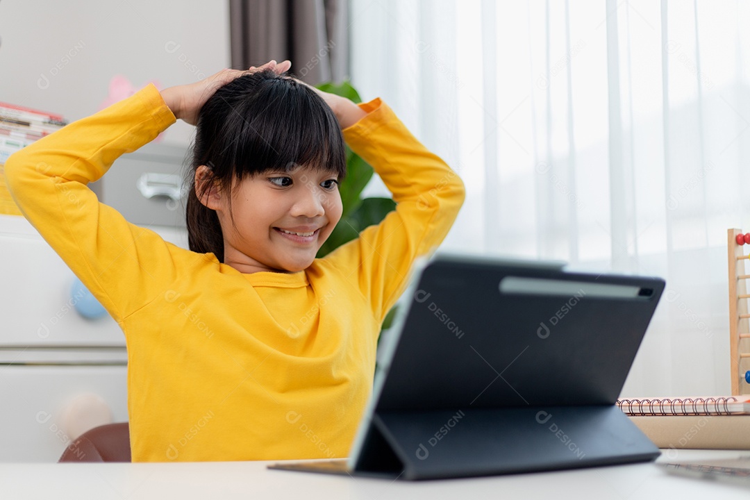 Aluna asiática fazendo sua lição de casa com tablet digital em casa.