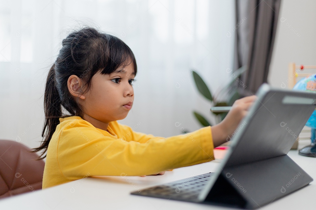 Aluna asiática fazendo sua lição de casa com tablet digital em casa.