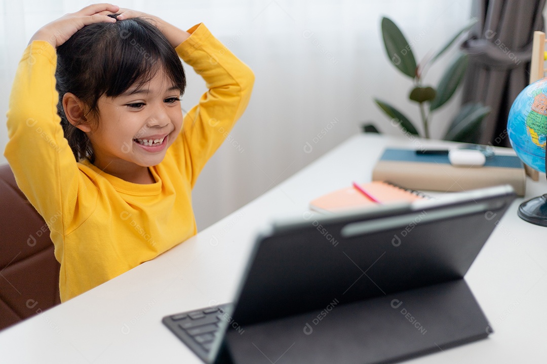 Aluna asiática fazendo sua lição de casa com tablet digital em casa.