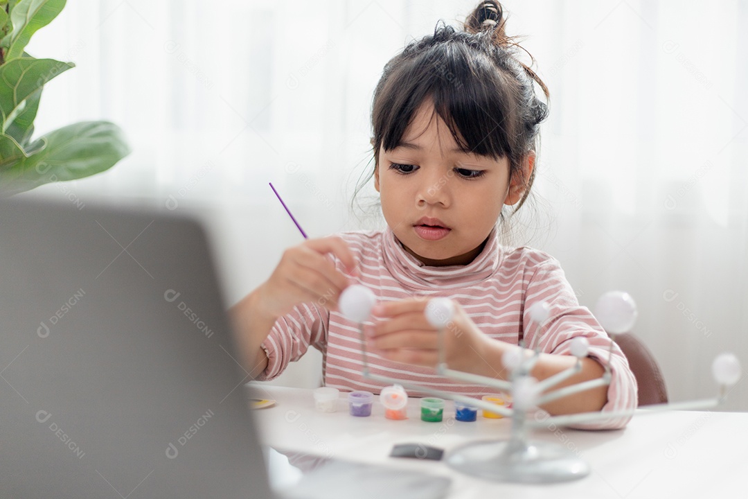 Menina asiática estuda o sistema solar na aula de geografia.