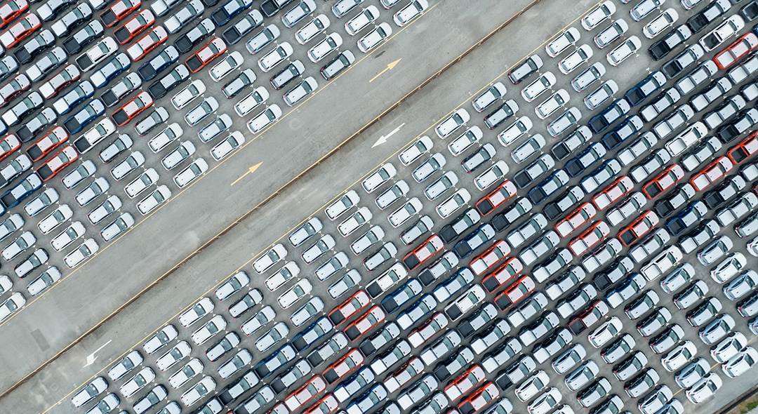 Vista aérea do estoque de carros novos no estacionamento da fábrica. Vista superior