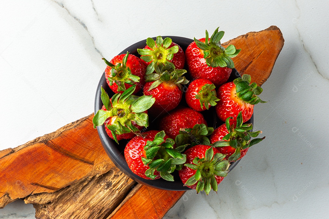 Sobremesa de morango servida em uma jarra em uma tábua de madeira e mármore