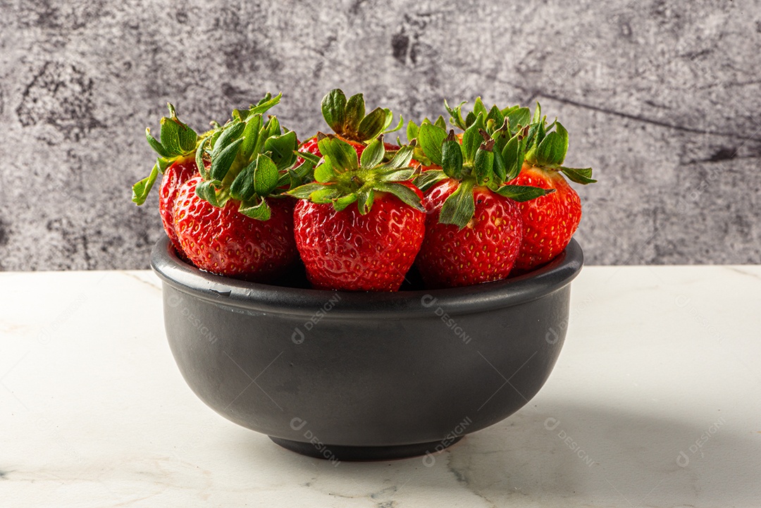 Sobremesa de morango servida em uma jarra em uma tábua de madeira e mármore