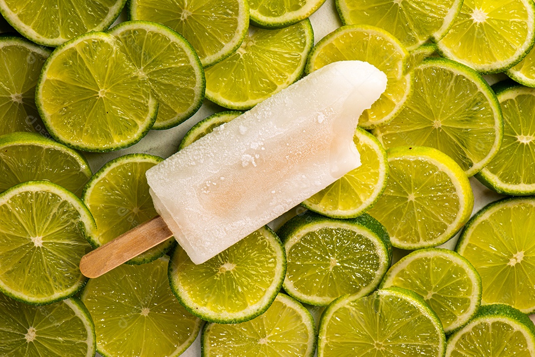 Picolé de Limão em fundo coberto de limão taiti cortados em rodelas