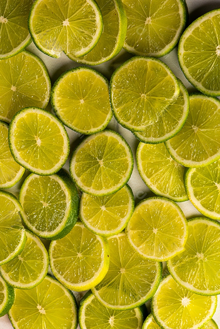 Imagem de fundo coberto de limão taiti cortados em rodelas