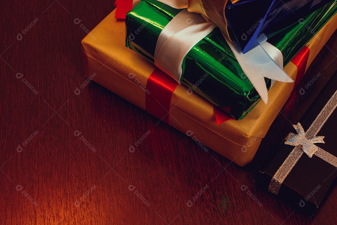 Vários presentes de natal e ano novo de enfeites feitos à mão em uma mesa de madeira.