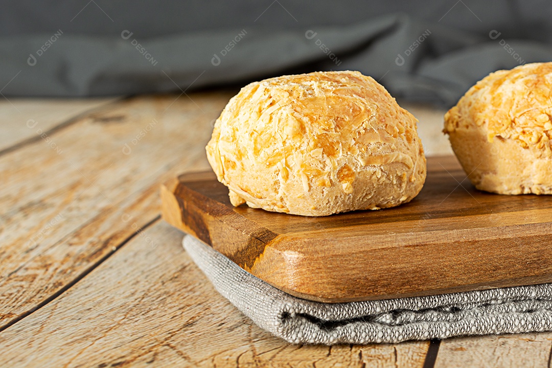 Mão pegando pão de queijo, uma comida tradicional brasileira