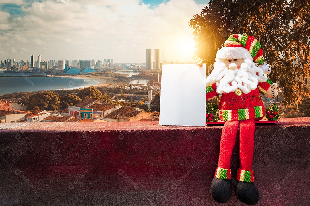 Santa Claus doll and paper card with copy space. Christmas decorations on a city background