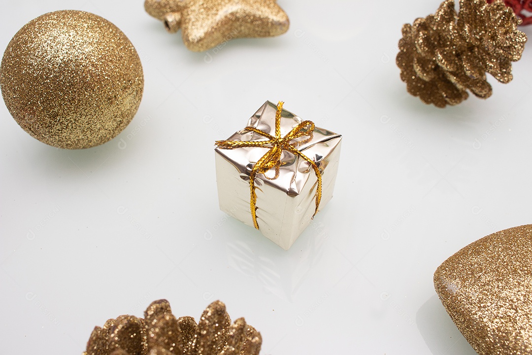 vários enfeites de natal dourados e vermelho sobre fundo branco