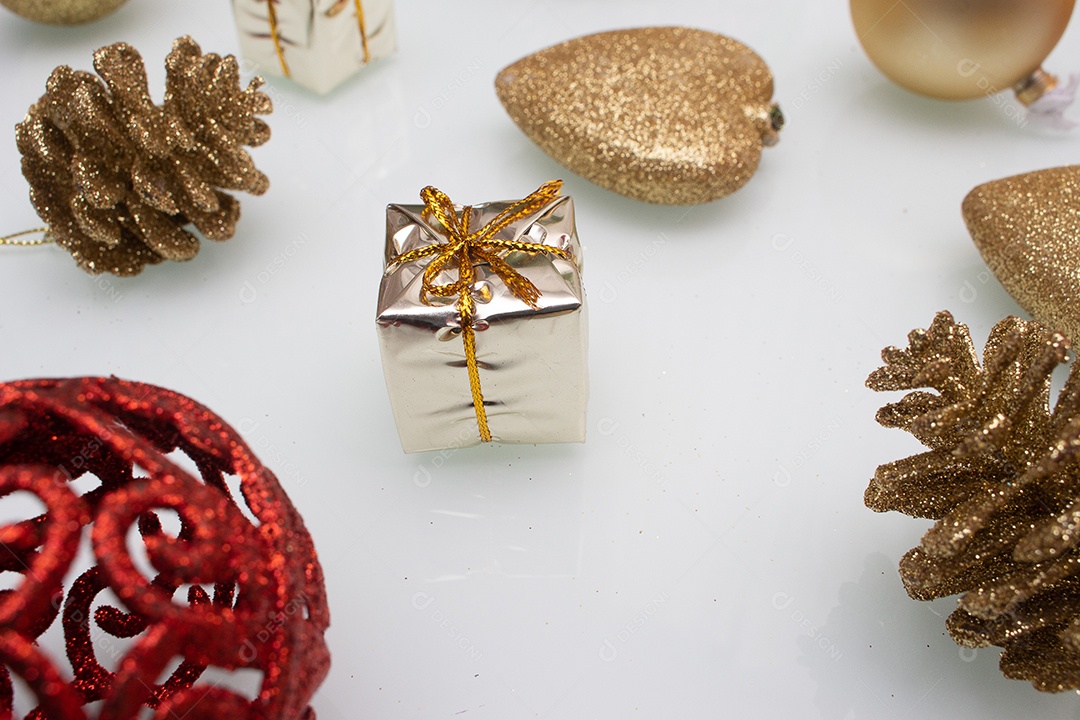 vários enfeites de natal dourados e vermelho sobre fundo branco