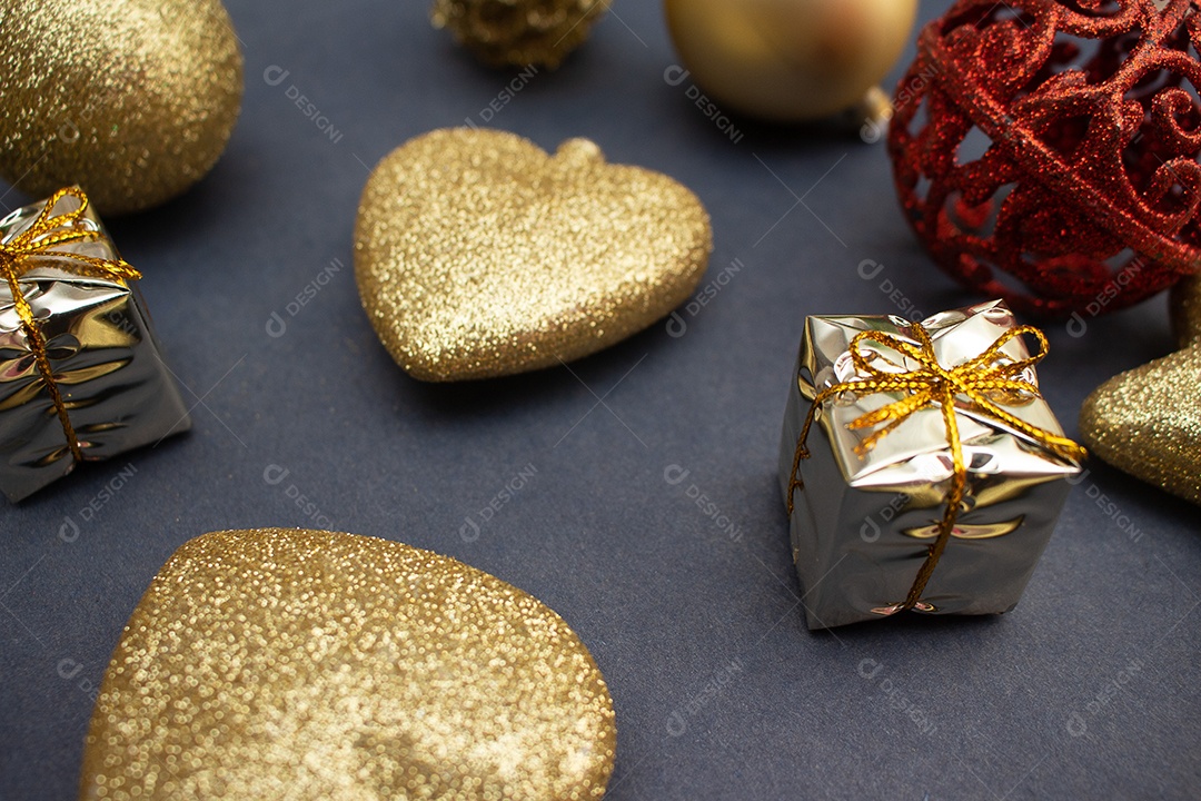 vários enfeites de natal dourados e vermelho sobre fundo preto