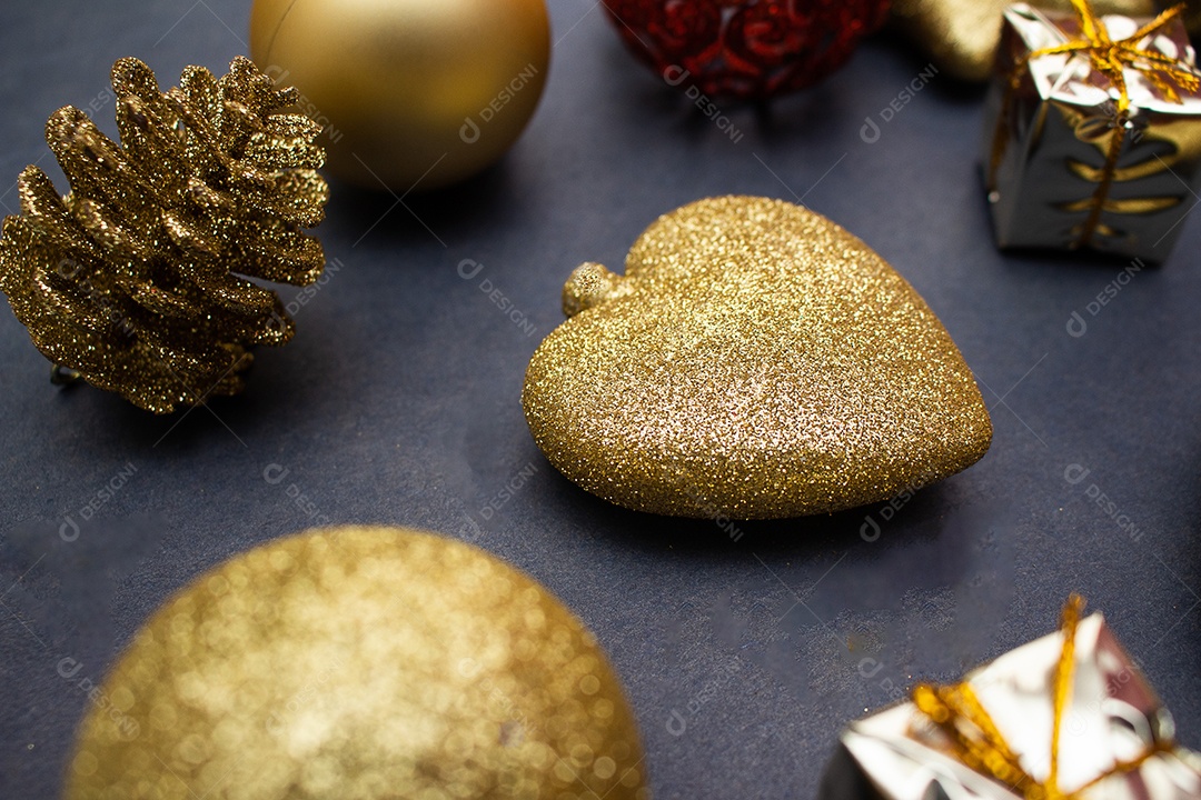 vários enfeites de natal dourados e vermelho sobre fundo preto