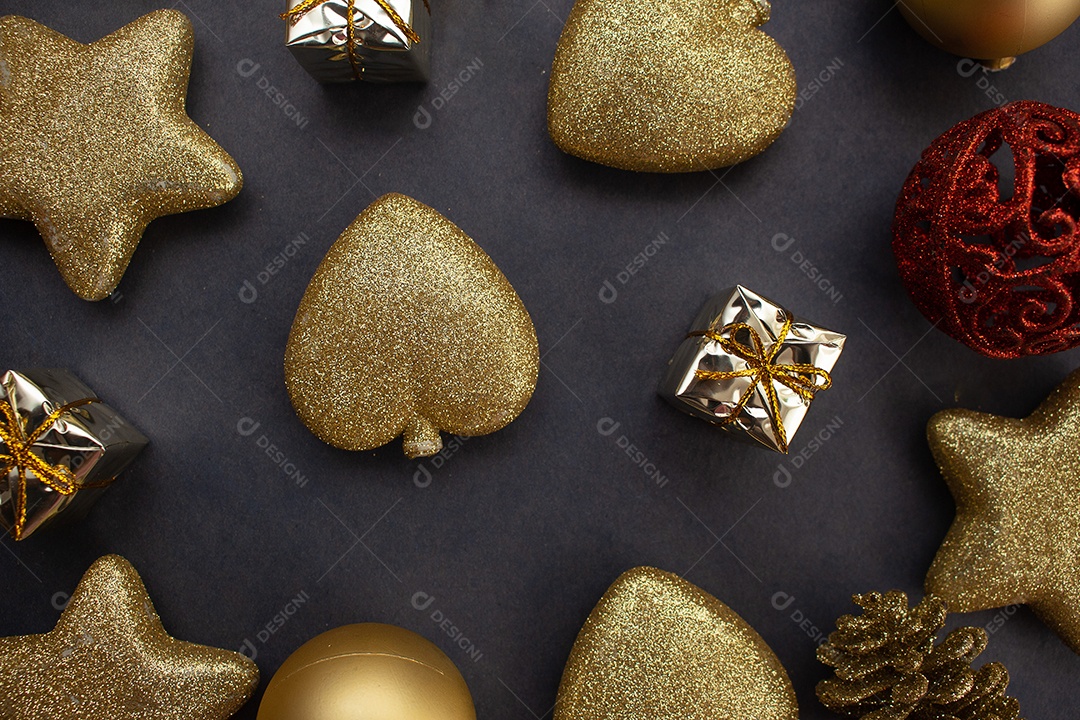 vários enfeites de natal dourados e vermelho sobre fundo preto