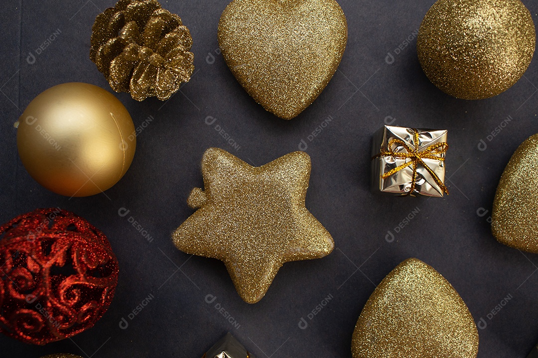 vários enfeites de natal dourados e vermelho sobre fundo preto