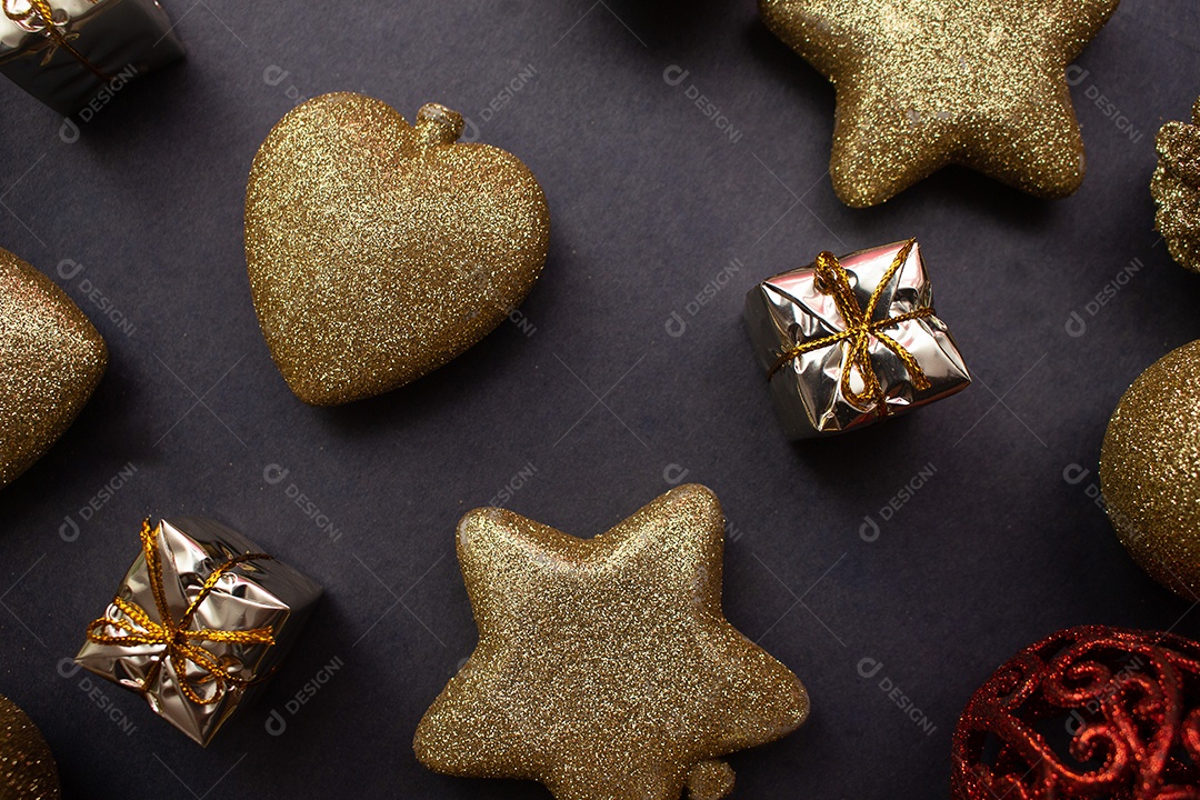 vários enfeites de natal dourados e vermelho sobre fundo preto