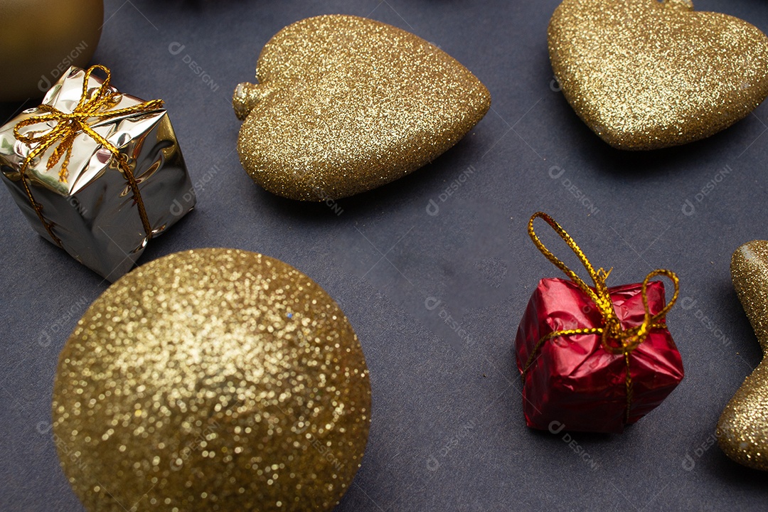 vários enfeites de natal dourados sobre fundo preto