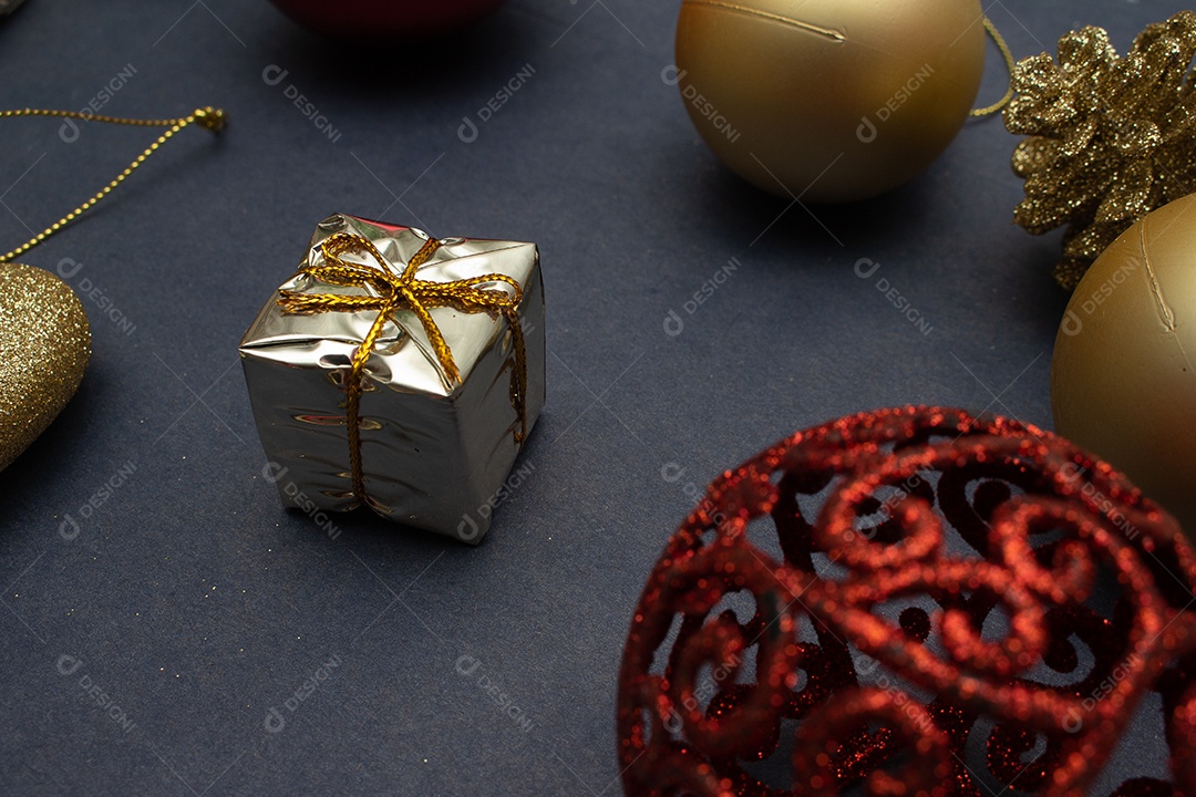 vários enfeites de natal dourados e vermelho em fundo preto