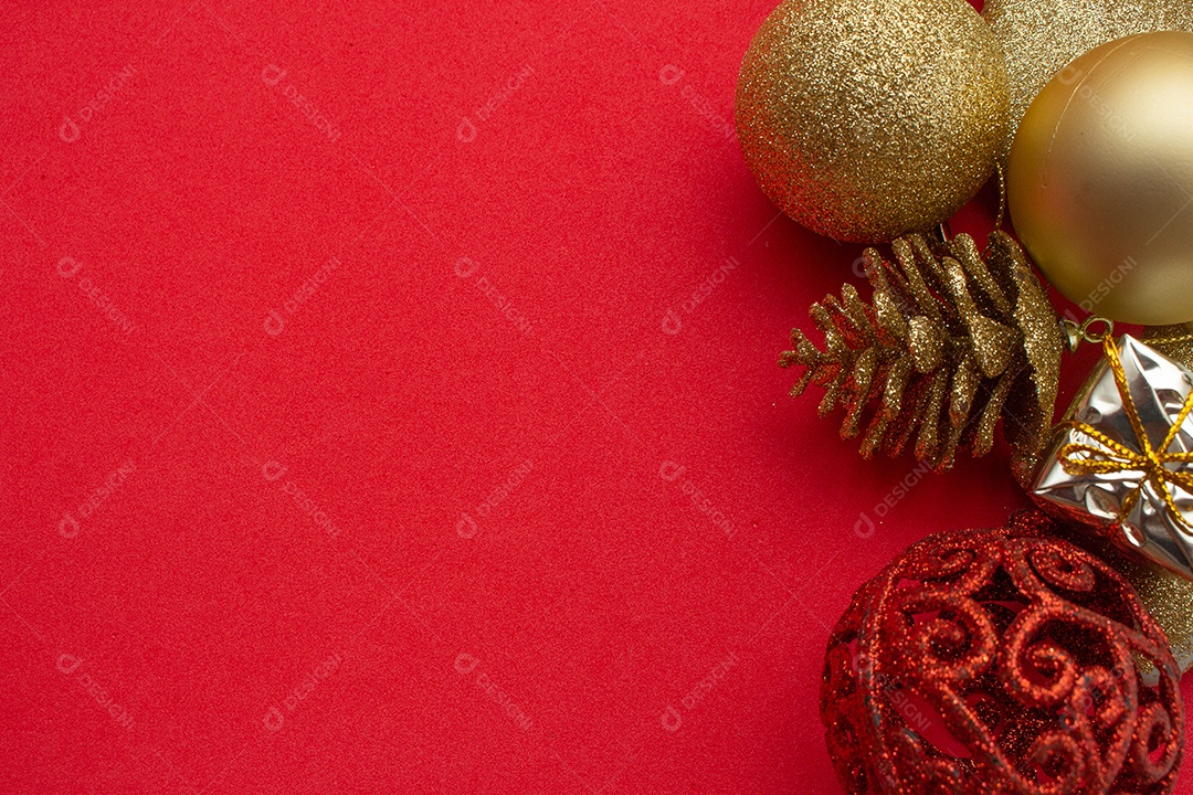 vários enfeites de natal dourados sobre fundo vermelho
