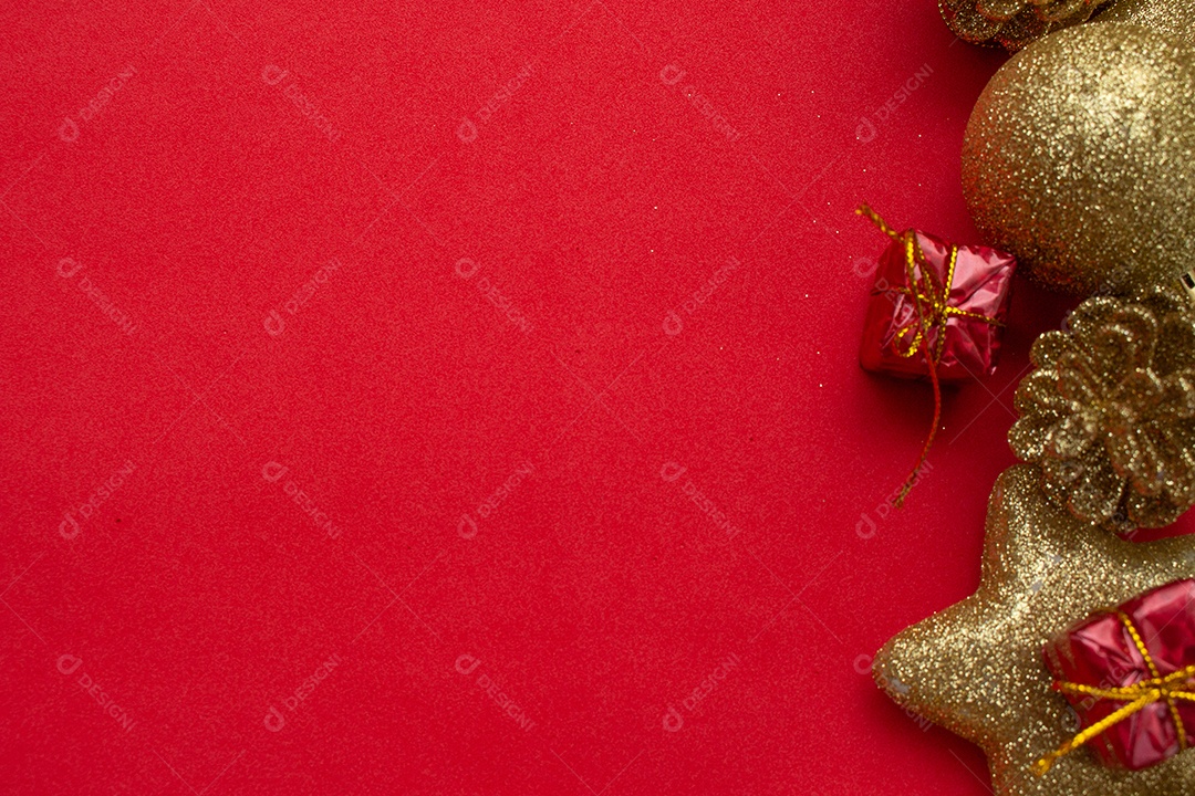 vários enfeites de natal dourados sobre fundo vermelho