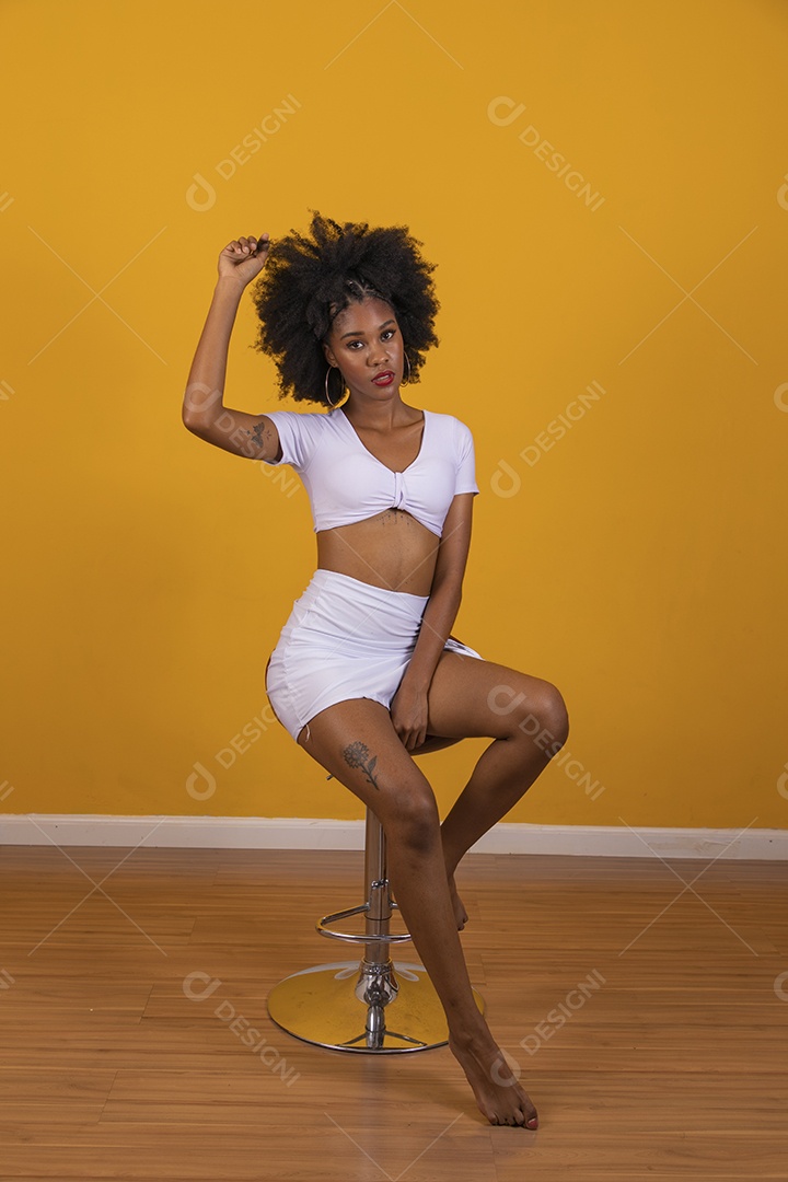 Linda mulher jovem negra cabelo afro cacheado pousando para fotografias
