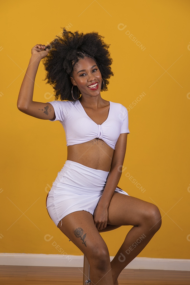Linda mulher jovem negra cabelo afro cacheado pousando para fotografias