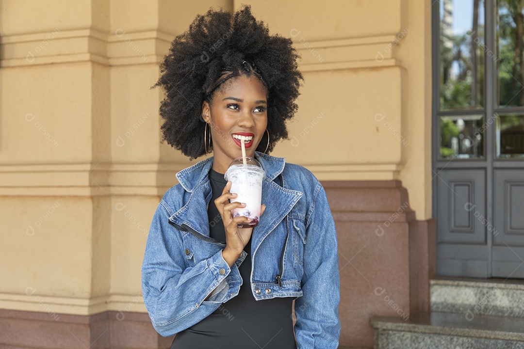 Linda mulher jovem negra cabelo afro cacheado tomando sorvete
