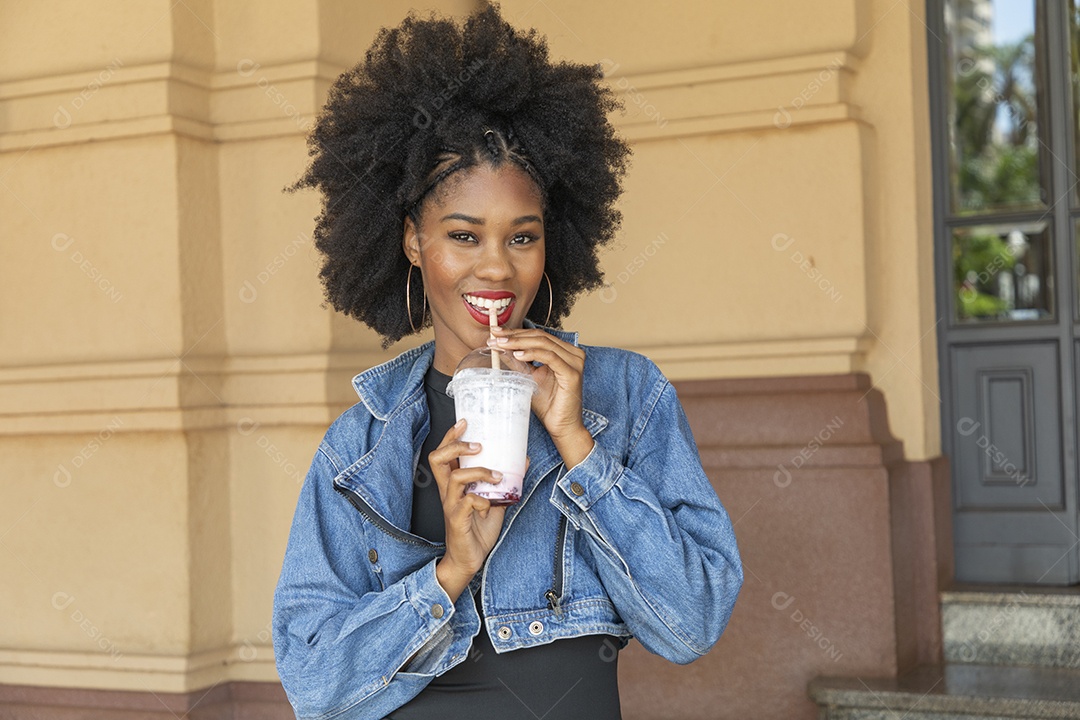 Linda mulher jovem negra cabelo afro cacheado tomando sorvete