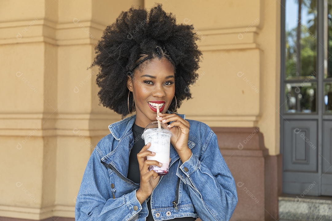 Linda mulher jovem negra cabelo afro cacheado tomando sorvete