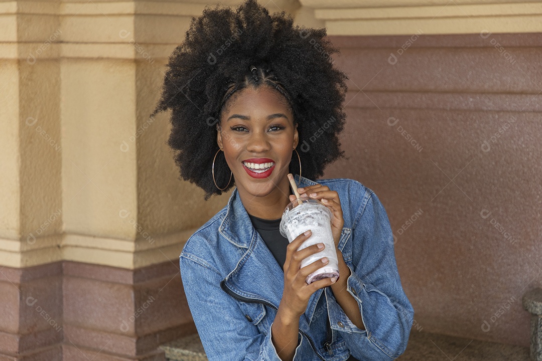 Linda mulher jovem negra cabelo afro cacheado tomando sorvete