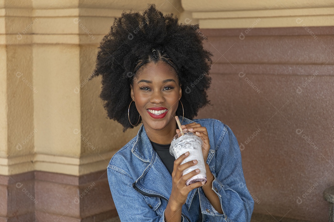 Linda mulher jovem negra cabelo afro mexendo em seu celular