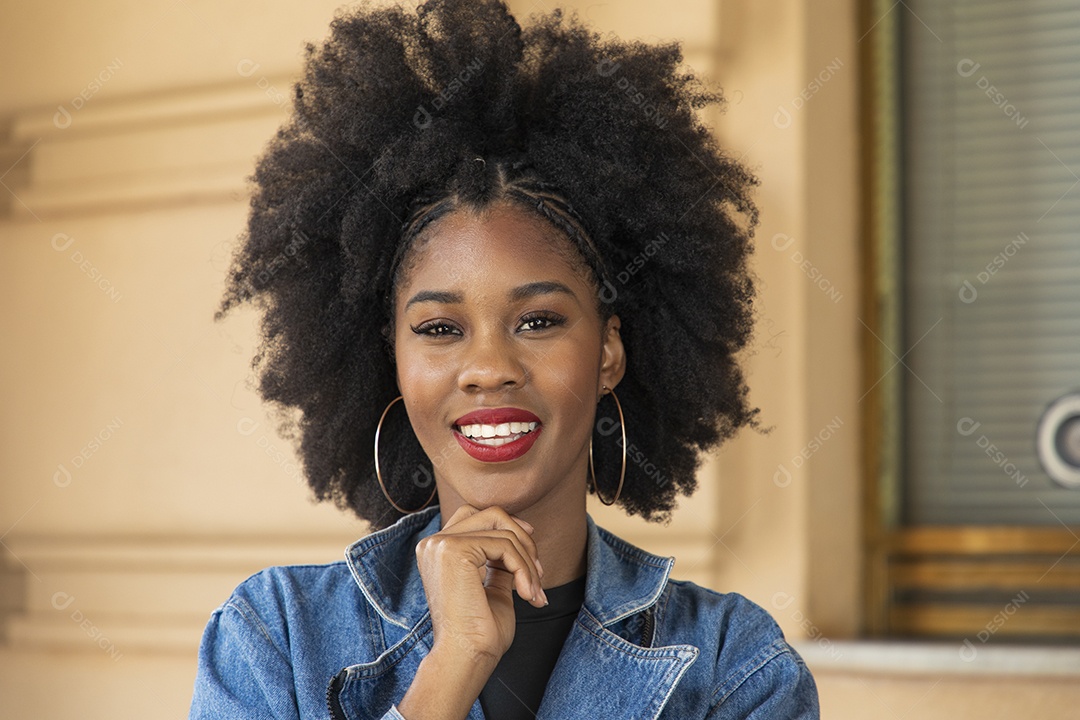 Linda mulher jovem morena cabelo cacheado afro sobre fundo edifício
